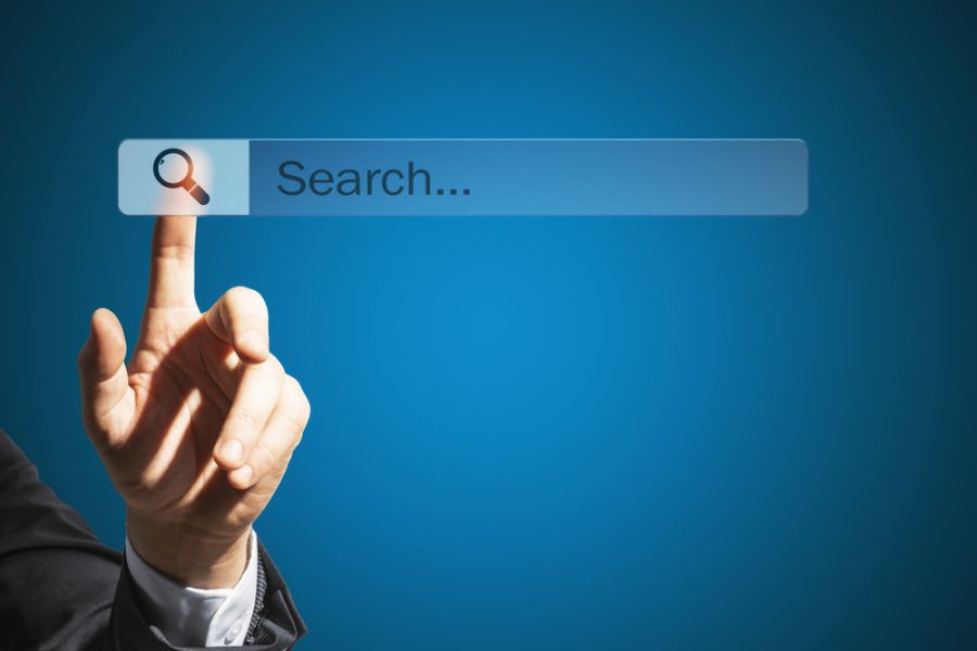 Man's Hand Touching an Internet Search Bar